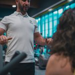 Sesión de entrenamiento en el gimnasio con un entrenador personal, enfocada en el rendimiento y el bienestar físico.